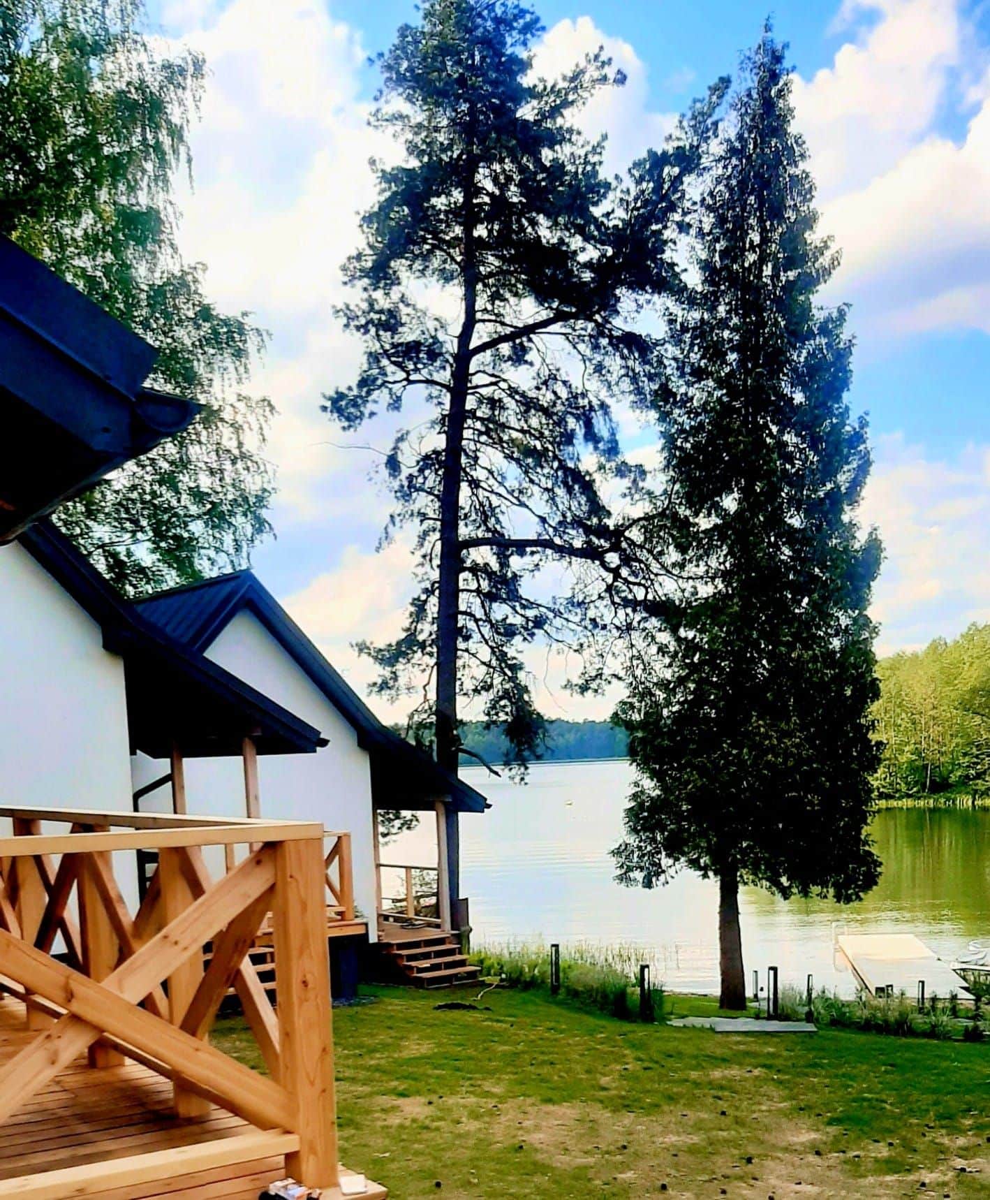 Domki nad jeziorem z miejscem na rowery, otoczone zielenią i spokojną wodą.
